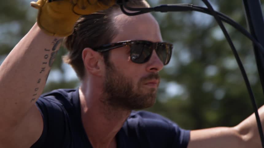 Bearded man riding a motorcycle on a clear day