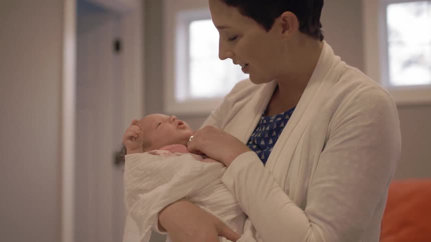 Woman comforting a crying infant in her arms