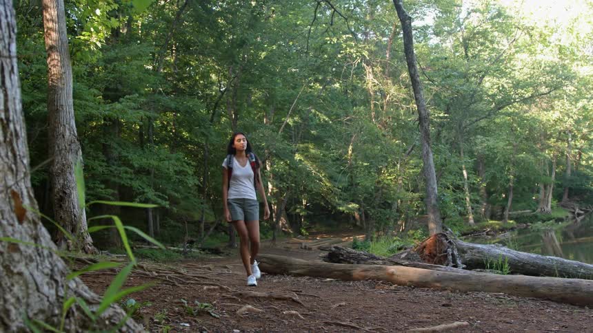 A woman hikes through the woods