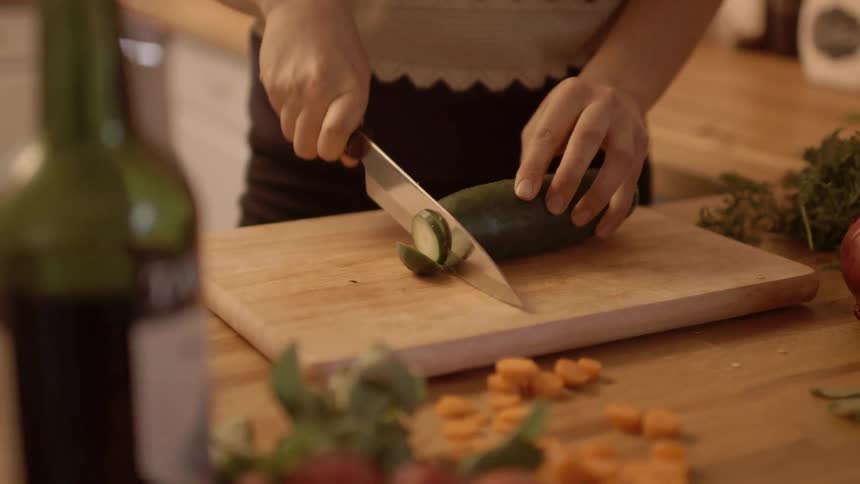 A person is cutting a cucumber