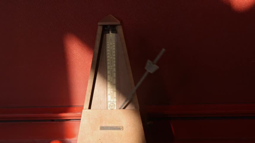 A metronome steadily rocking back and forth