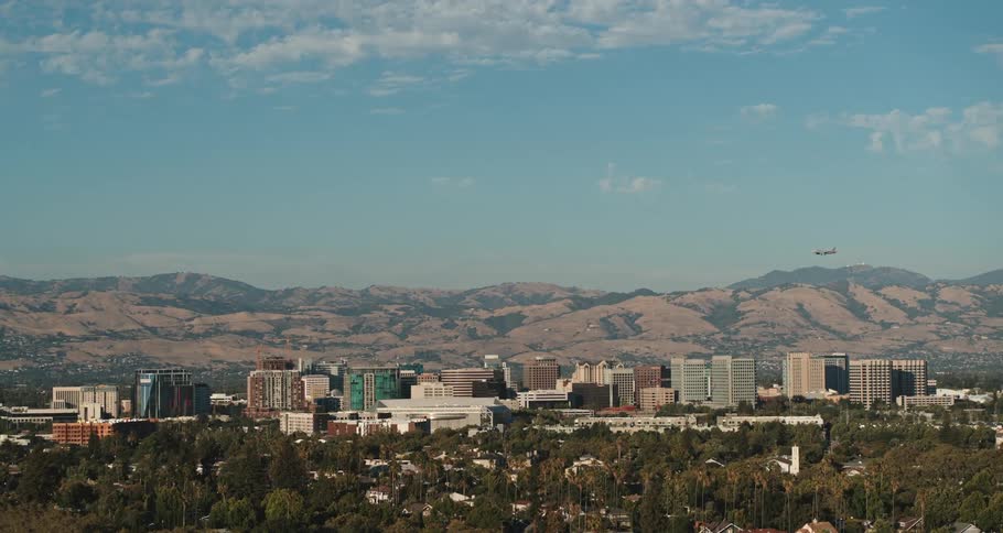 A plane flies over a city location near a canyon