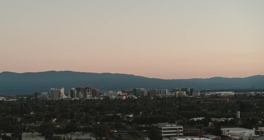 City buildings and streets with mountains on the horizon