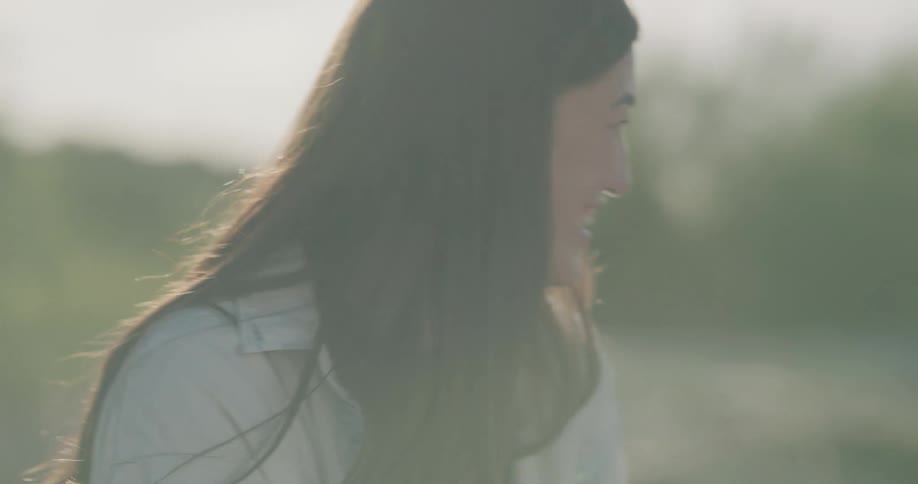 Asian woman sitting at the ground while holding a beverage and chatting with her friends