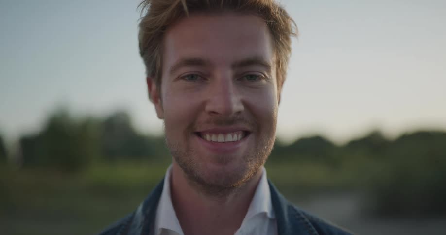 A man outside looks up and smiles