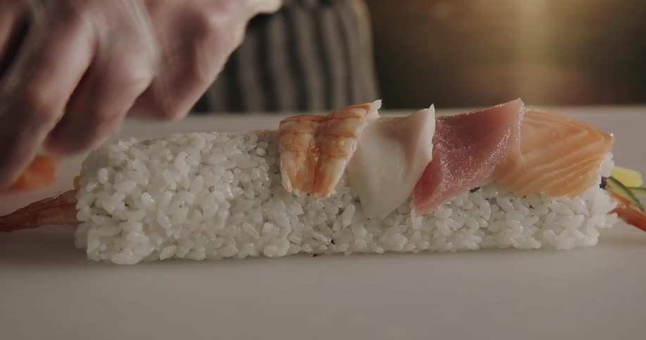 A person laying fish on rice
