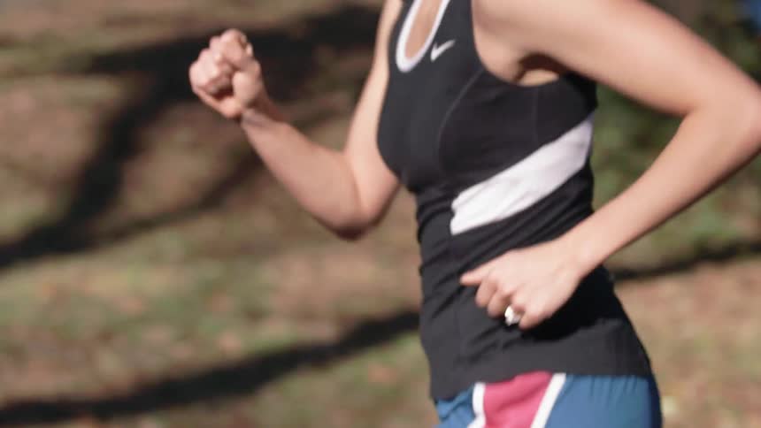 A woman in black runs during the day
