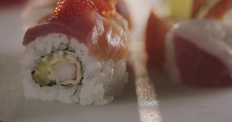 Pieces of sushi rolls are separated on a white plate