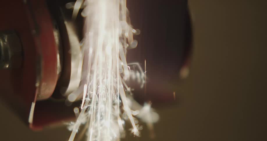 Sparks fly as a metal grinder moves forward