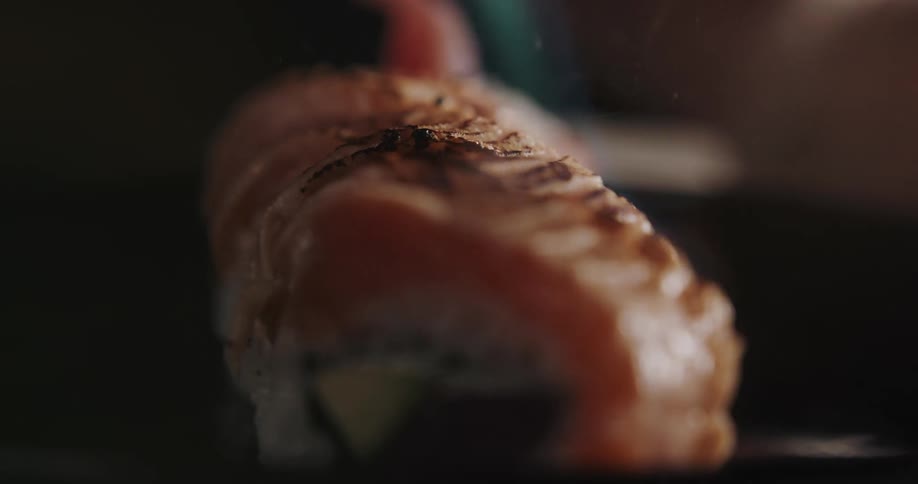 Sushi being cooked with a torch flame