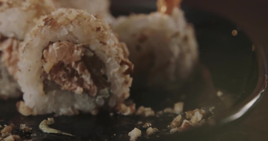 A piece of food being picked up by chopsticks