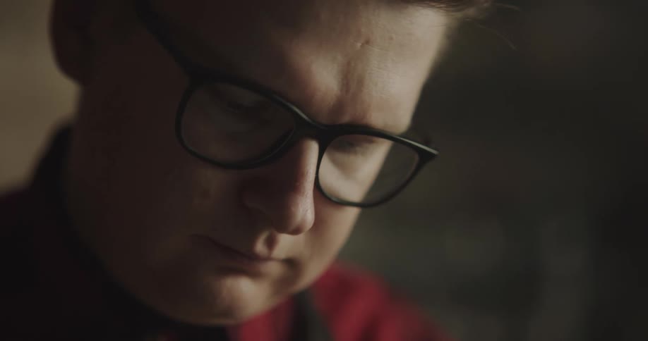 A young man looks down as he concentrates