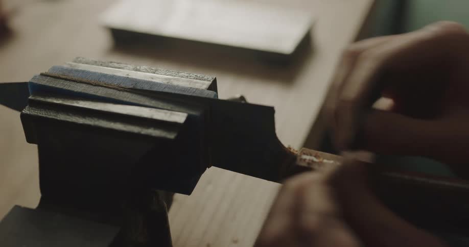Blade of a knife is held in a clamp while the handle is being shaved