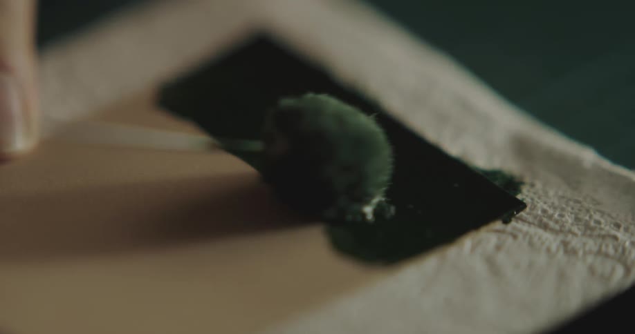 A brush putting paint on a canvas