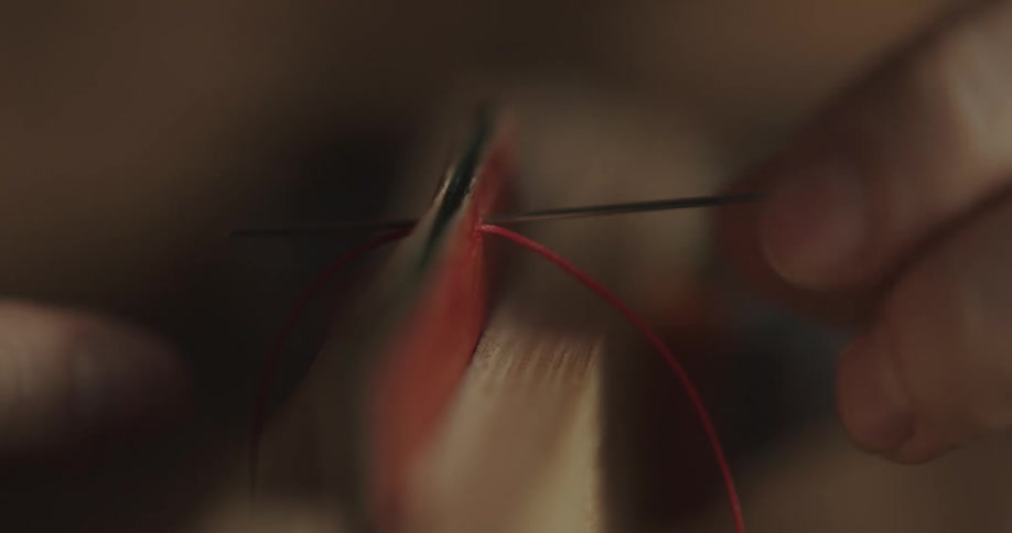 A person sewing with a needle and thread