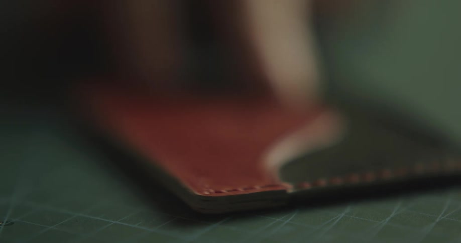 A person with a tool shaving leather