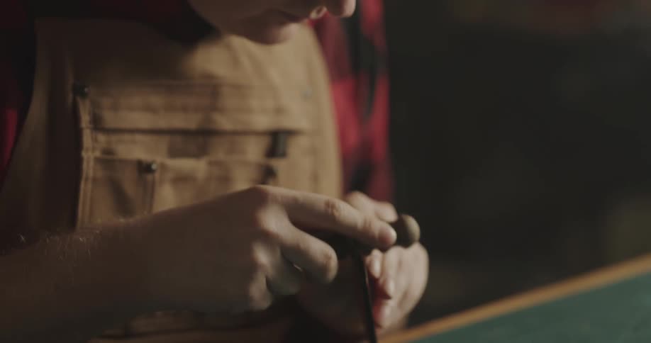 A man is carving wood with a tool