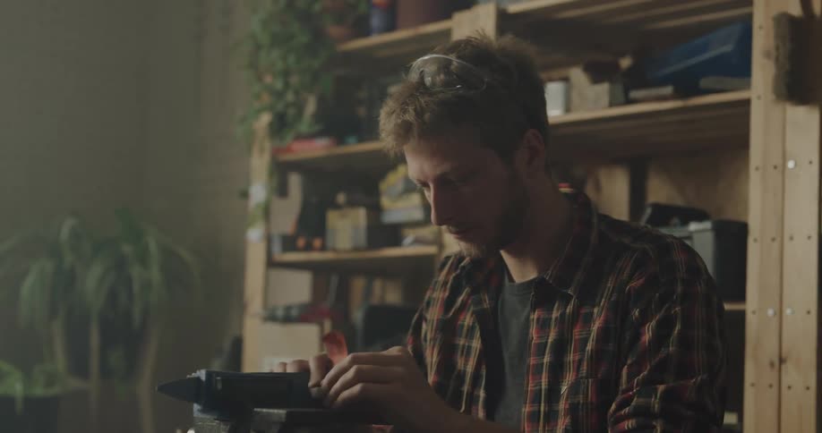 A man at home uses a sander