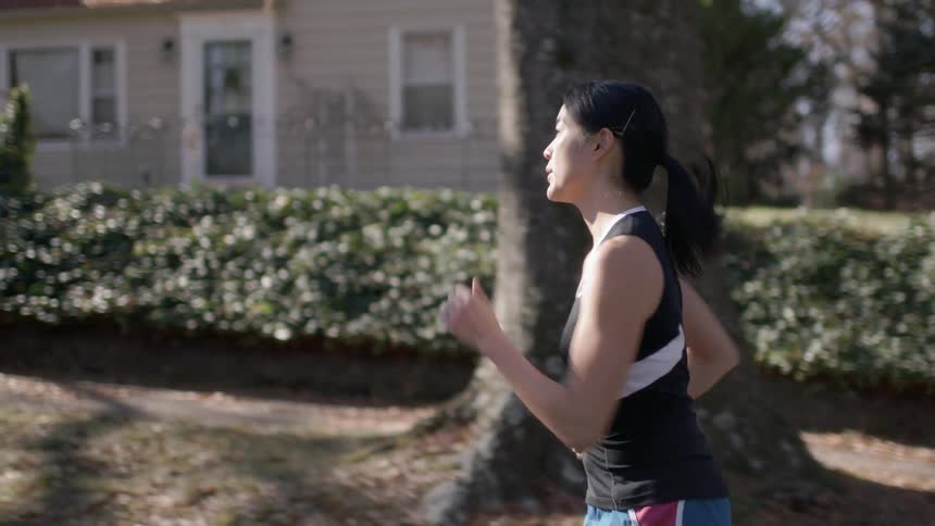A woman is running outside through a neighborhood