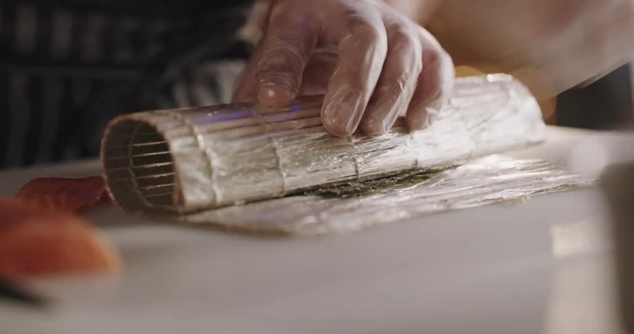 A person rolls sushi