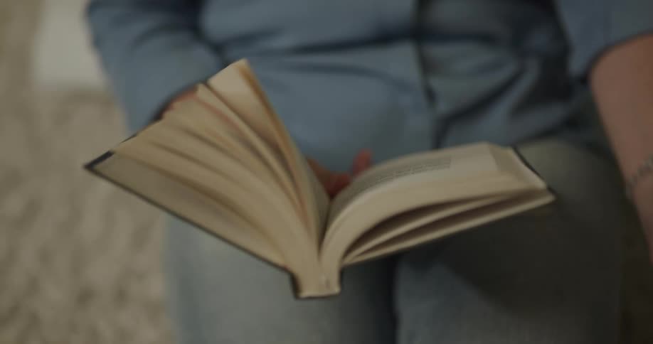 A person reading a book next to their dog