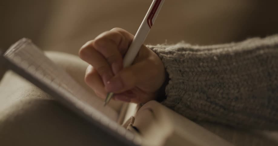 A person reading and writing in a book