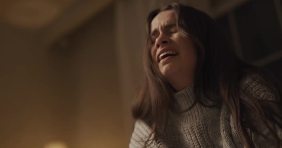 A woman holds her head as she sobs and weeps