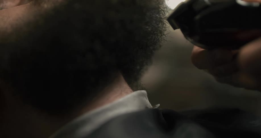 Man getting his beard trimmed with a beard trimmer at a barber shop