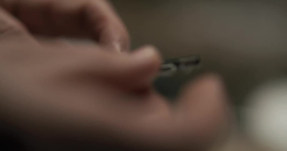 A man takes the cover off of a small tool