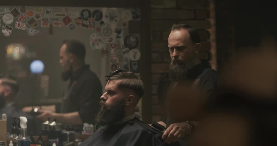A barber shaves a section of a mans head and spins him around in the salon chair
