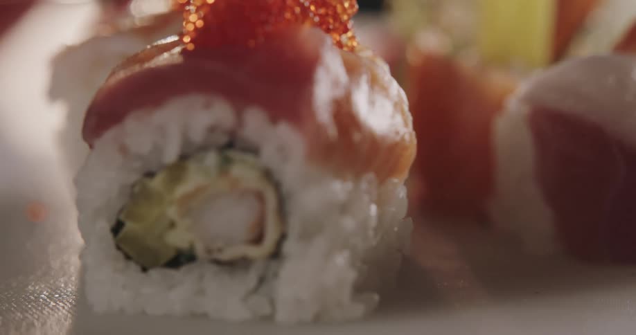 Fish topped rice rolls sit on white plate