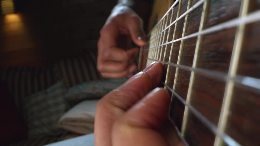 A close up of a person playing a guitar