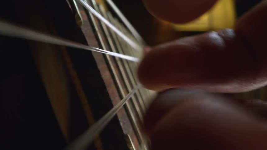 A person picking at guitar strings