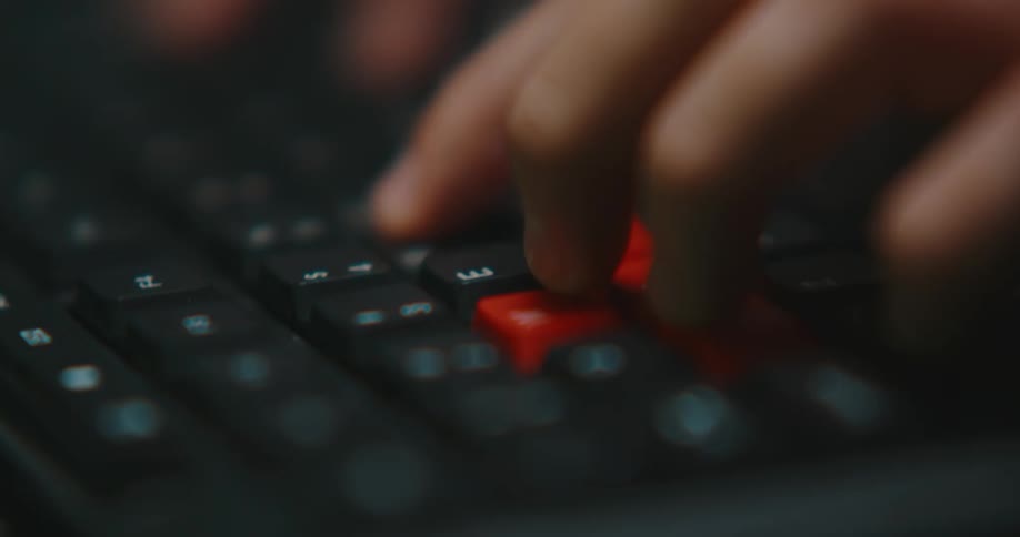 Close up of a persons hand as they type on a keyboard