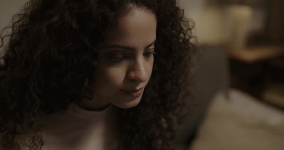 Woman with long curly hair nods while conversing