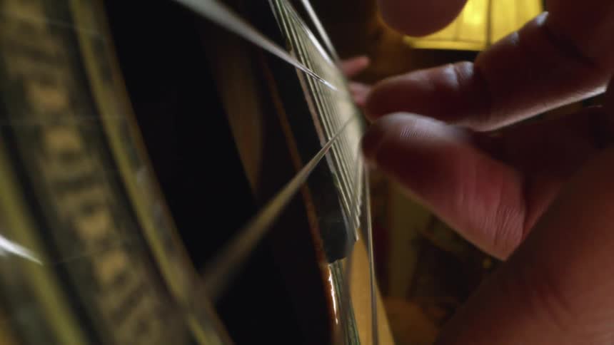 Close up of a person picking guitar strings
