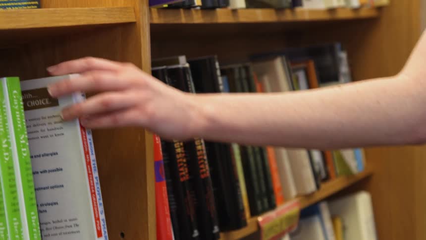 A woman is browsing books in a library