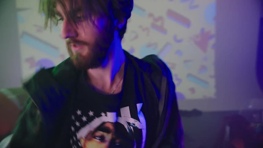 A young man dances in his bedroom as lights flash