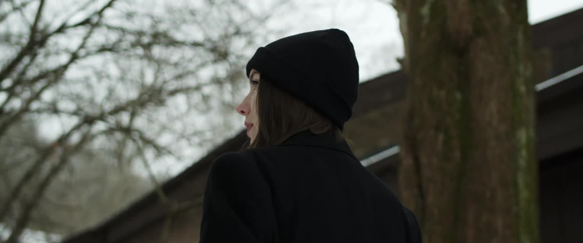 White woman wearing winter clothing walking alone in the street