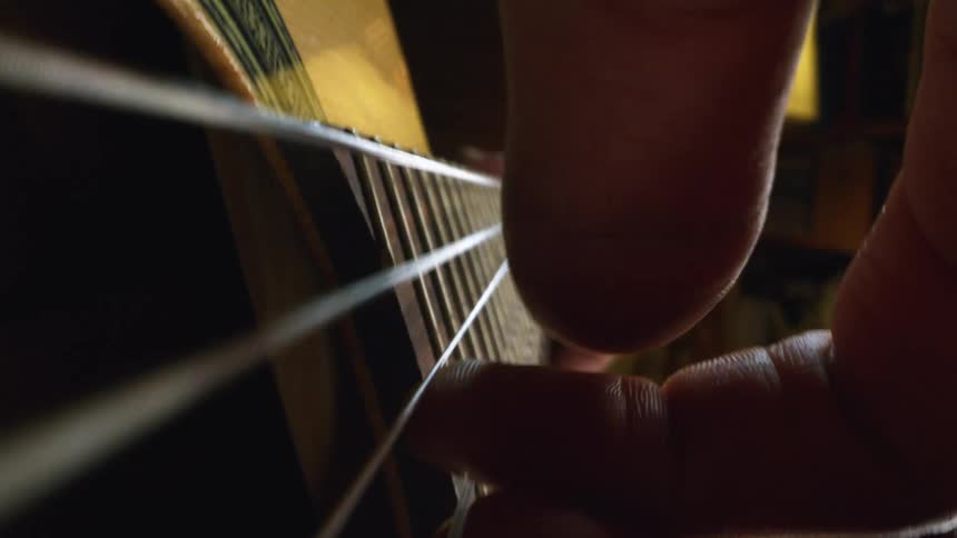 A close up of a person playing guitar