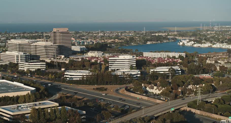A city with road vehicles and buildings with the sky and clouds in the background