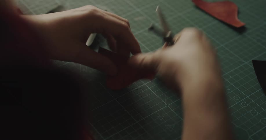 A woman cuts a piece of paper while crafting