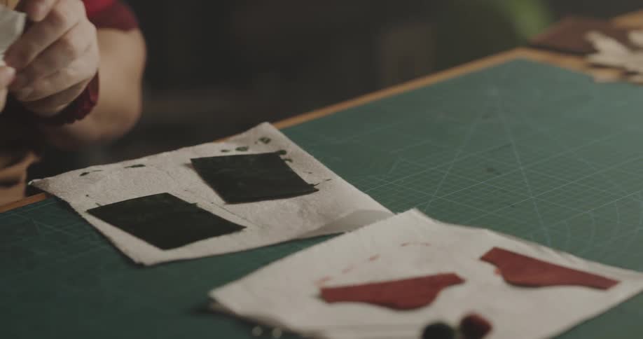 An employee working on leather in a studio