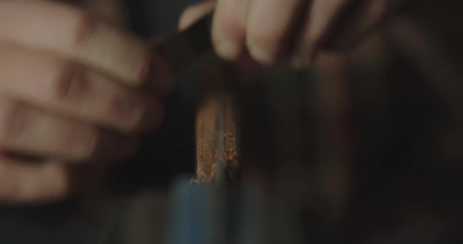 A person is sharpening the wood