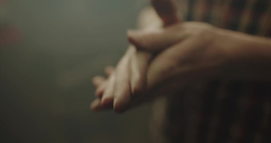 A man is touching his hands indoors