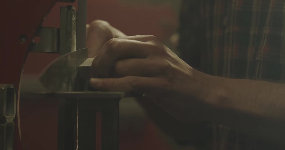 A man grinding a piece of wood