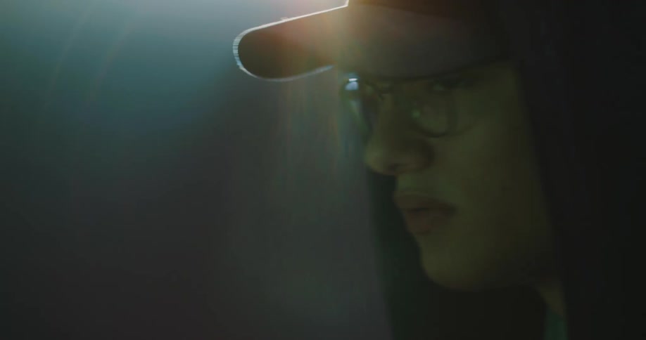 A person in a hoodie standing around looking around