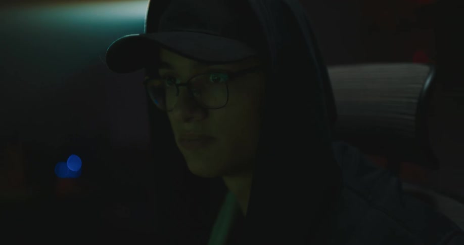 A woman is drinking from a glass at night