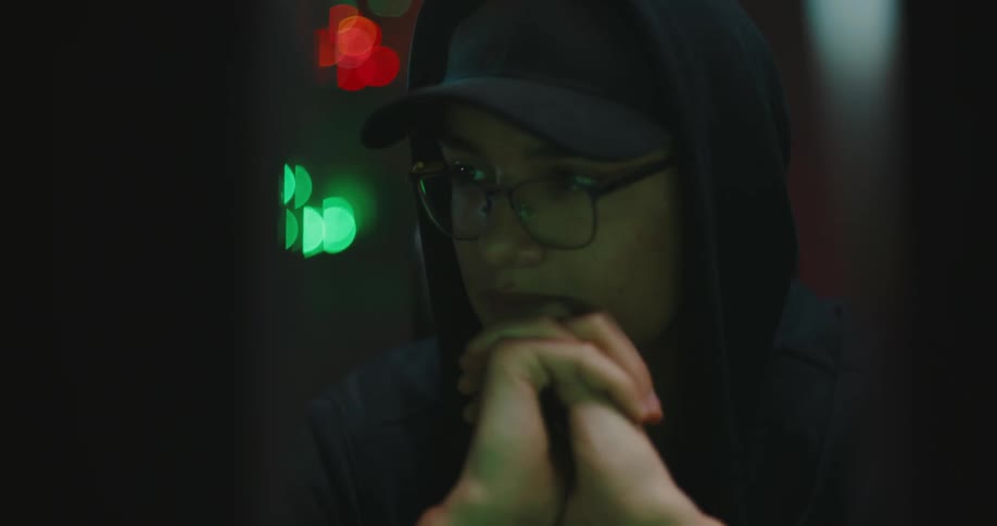 A man in a room with a hat hoodie and glasses