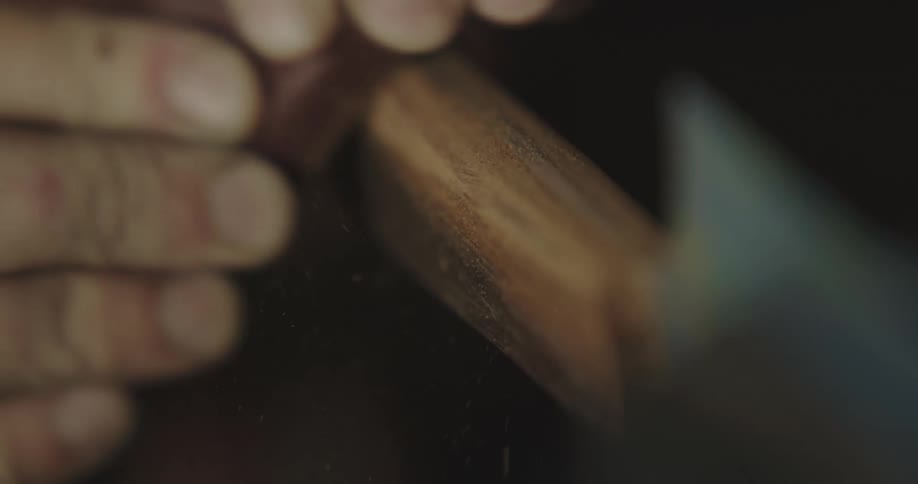 An employee sanding a handle on a knife